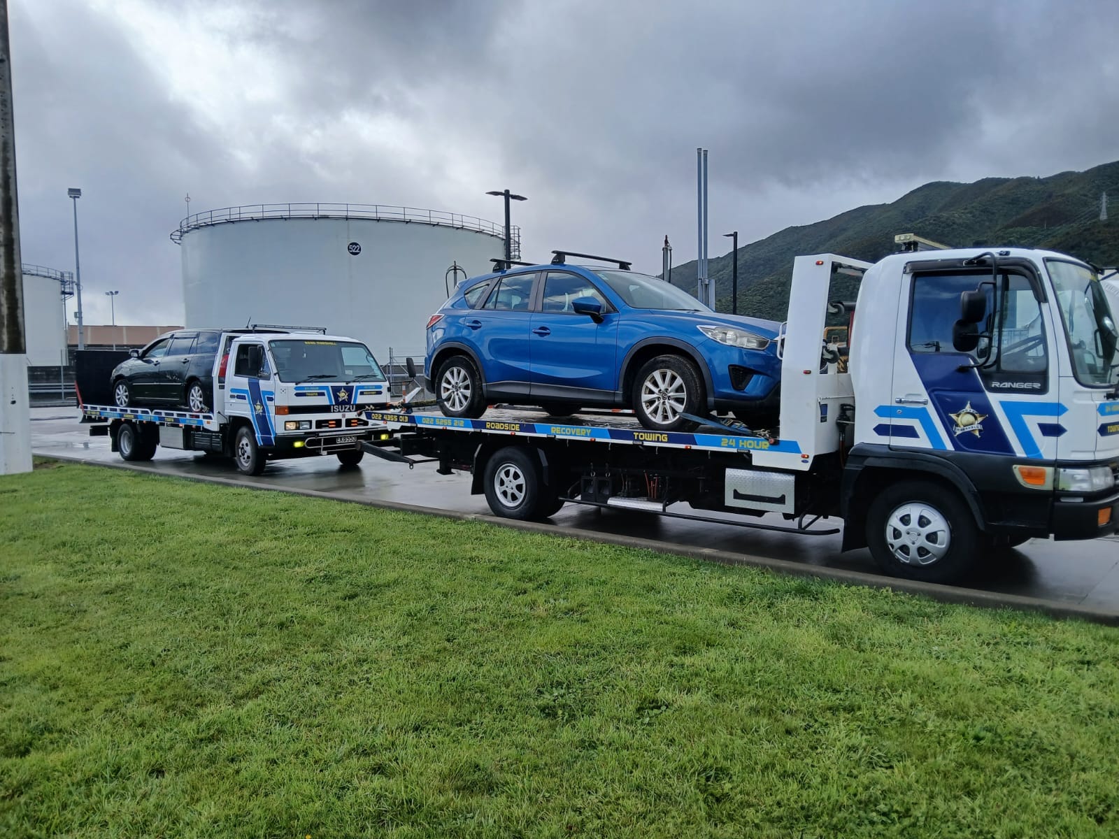 Road Marshall truck towing another recovery vehicle carrying a Mazda